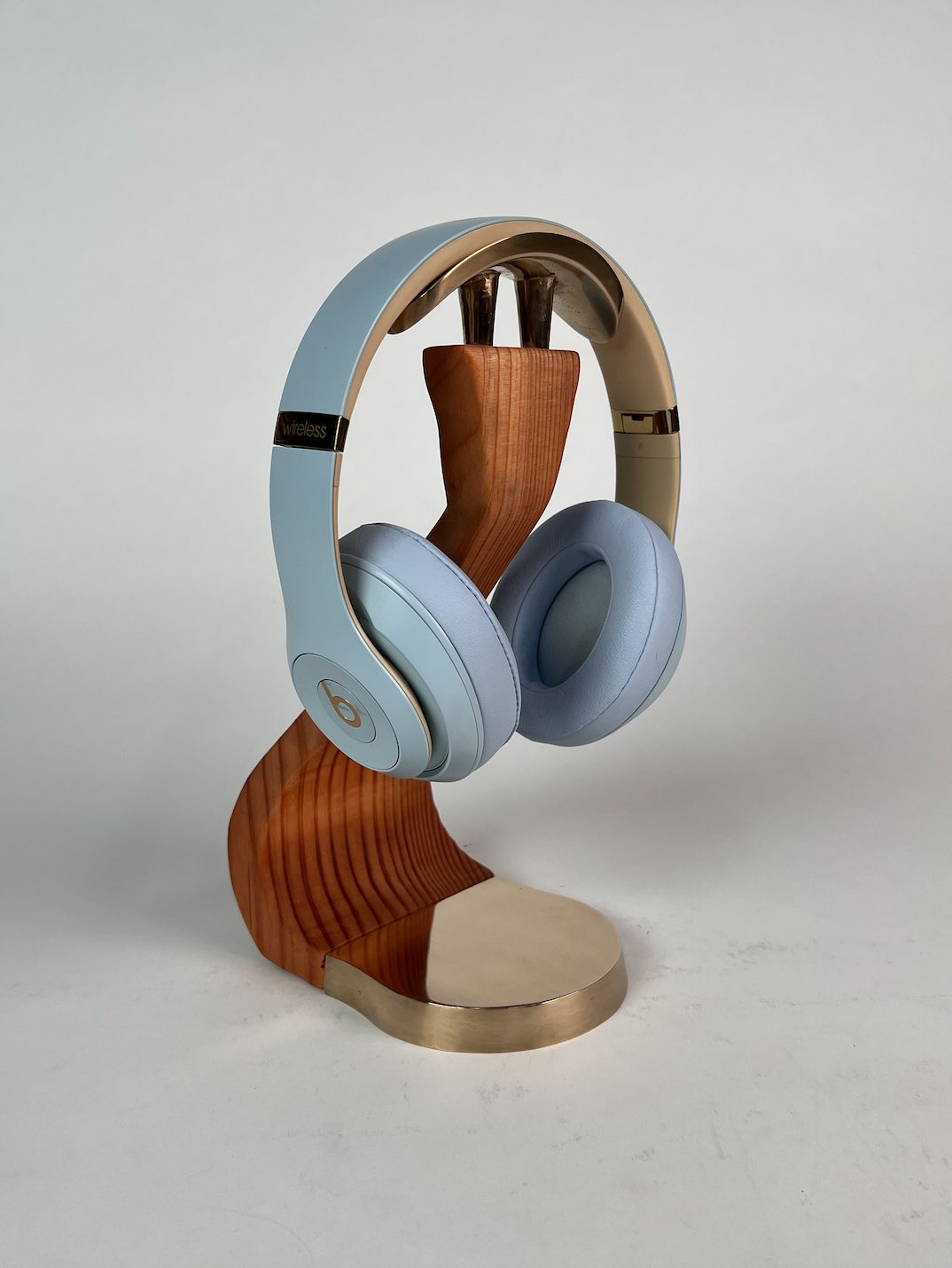 Headset Habitat: headphones resting on a bronze and cherry-wood stand